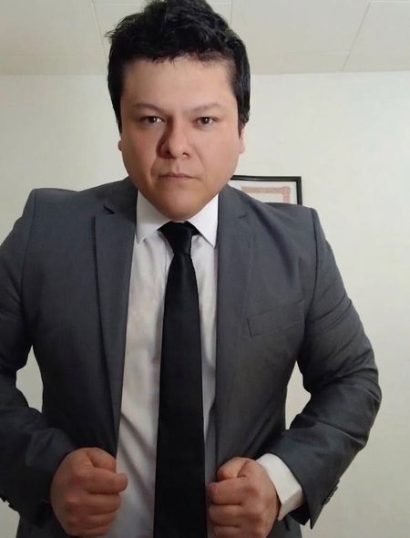 Retrato del Dr. David Alejandro Viscarra ajustándose el saco de su traje.